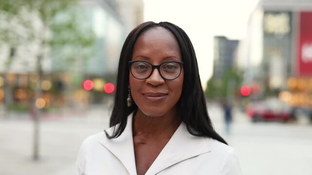 Elegant woman wearing glasses smiling in the city center
