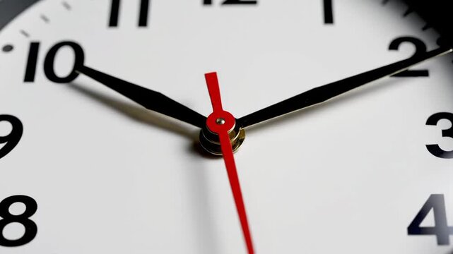 Close up of white analog clock face showing time.