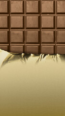 Naklejka na ściany i meble A vertical close-up of a classic milk chocolate bar, partially unwrapped from its elegant gold foil packaging