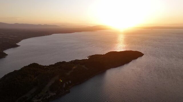 Aerial view of forested peninsula at golden hour, Chile lake district.