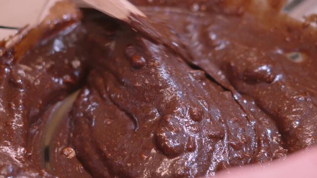 Wooden Spoon Slowly Turning Indulgent Chocolate Brownie Mix Batter in Kitchen. Perfect for Home Baking Cooking Tutorials and Recipe Video Concepts. 4K.