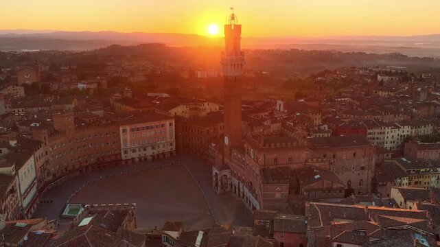 Tuscan city of Siena aerial sunrise view, piazza del Campo and Torre del Mangia drone view with morning sunlight, travel in Tuscany