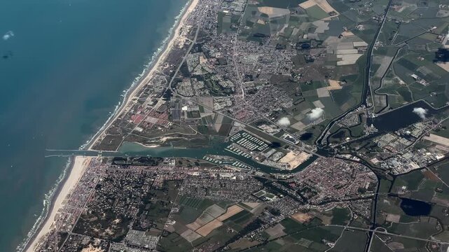 flying across the North Sea coastline with long white sandy beaches, with City of Nieuwpoort, Belgium located at River Yser and with Marina "Vlaamse Yachthaven", cityscape, streets, building