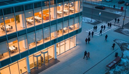 Naklejka premium Dominating glass office building featuring revolving door at plaza, people in winter coats crossing