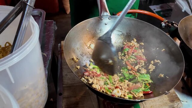 Thai Street Food Cook Preparing Omelet and Stir-Fried Pork in Dual Wok Station