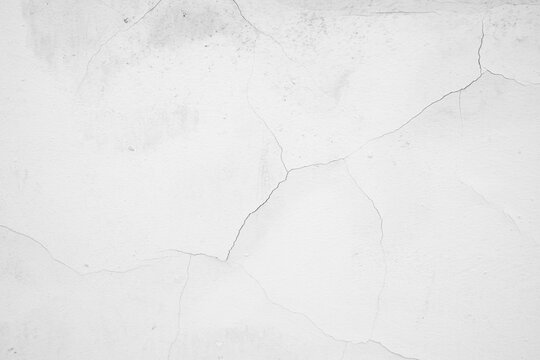 White plaster wall with fine cracks and textured surface
