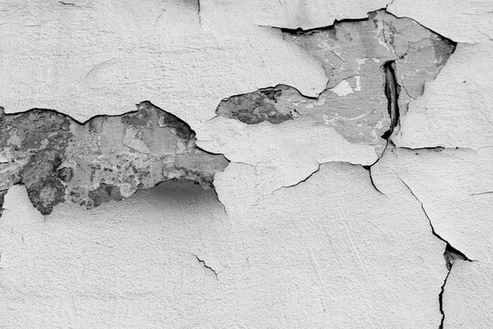 Cracked old plaster surface with visible texture and peeling paint detail