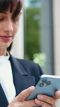 Young woman using mobile phone app , texting, playing game, shopping online, ordering delivery, outdoors. Happy girl sharing social media holding smartphone.