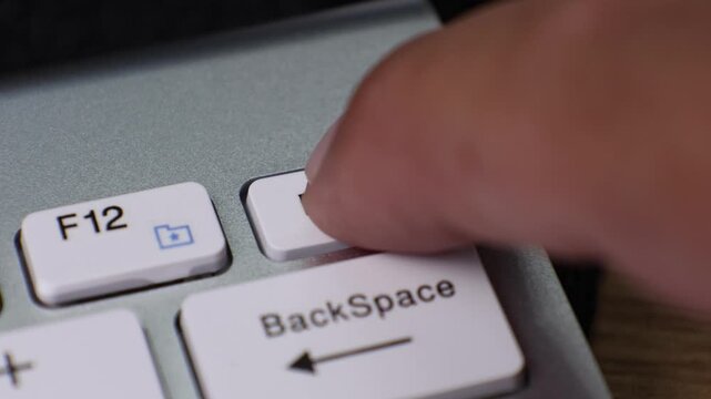 Close-up view of a computer keyboard focusing on the Delete key along with nearby keys like Backspace and F12.