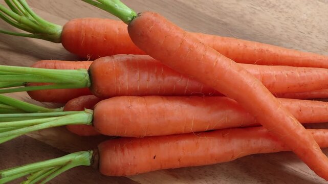 Fresh and sweet carrots on wooden floor.