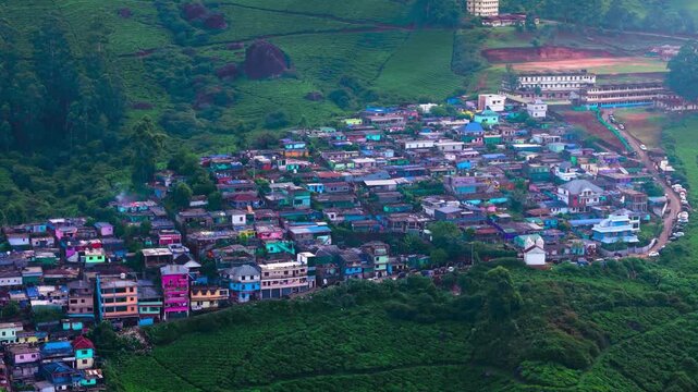 Scenic Aerial View of Green Mountain Landscape Surrounding a City Center with Urban Buildings, Lush Hills, Natural Environment, Cloudy Sky, Modern Development and Beautiful Cityscape Between Mountains