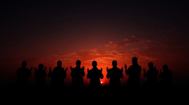 Silhouetted people praying at sunset