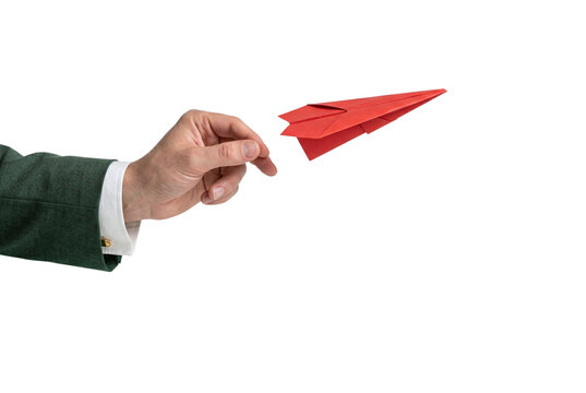 Business hand throwing red paper airplane