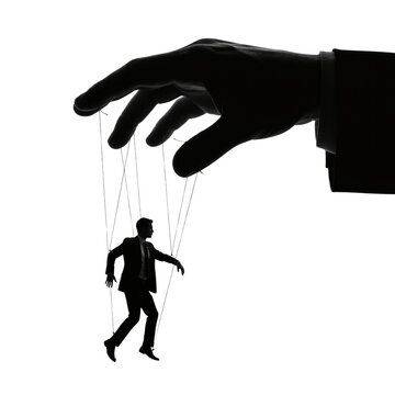 Giant hand controlling a businessman like a marionette puppet