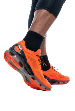 Close up of legs wearing bright orange running shoes