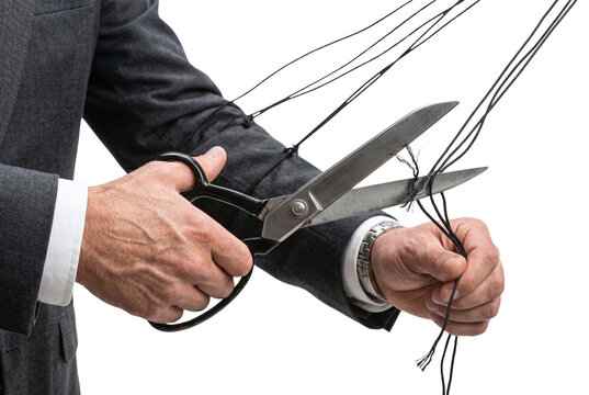 Businessman cutting puppet strings with scissors for freedom