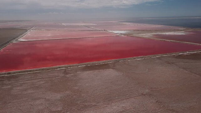 Aerial view of red salt pans and evaporation ponds in walvis bay, namibia, showing vibrant colors from algae and bacteria