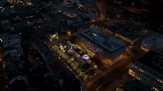 Aerial drone night view of &Uacute;st&iacute; nad Labem, showcasing the illuminated Church of the Assumption, M&iacute;rov&eacute; n&aacute;měst&iacute; square, and illuminated bridges spanning the Labe River under a dark sky