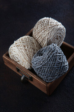 Wool tweed yarn in balls lies in wooden box. Yarn for knitting or crocheting. Handmade work. Hobby concept