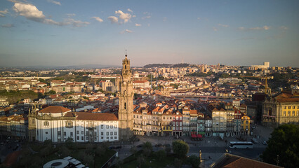 Obraz premium Aerial golden hour view of Torre dos Clerigos and Igreja dos Clerigos rising above the historic rooftops of Porto Portugal