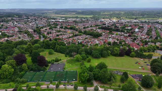 Reverse aerial drone view of Prospect Park Reading, showcasing sports fields and surrounding town