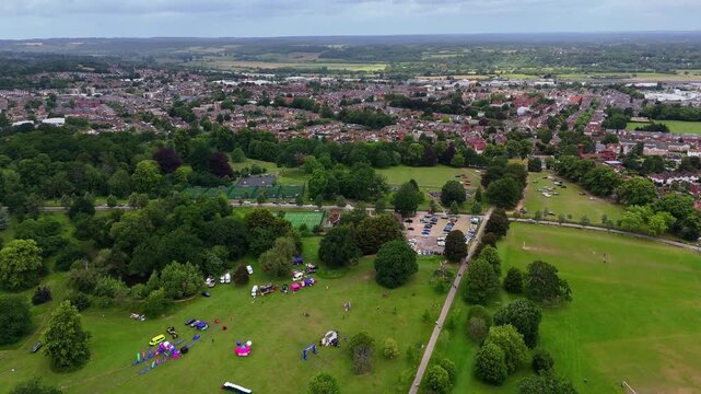 Aerial wide establishing shot of Prospect Park, Reading, UK, with people on grass