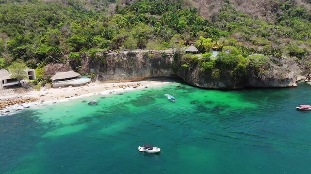 Drone view of boats floating on turquoise water at paredon beach, a tropical paradise in mexico