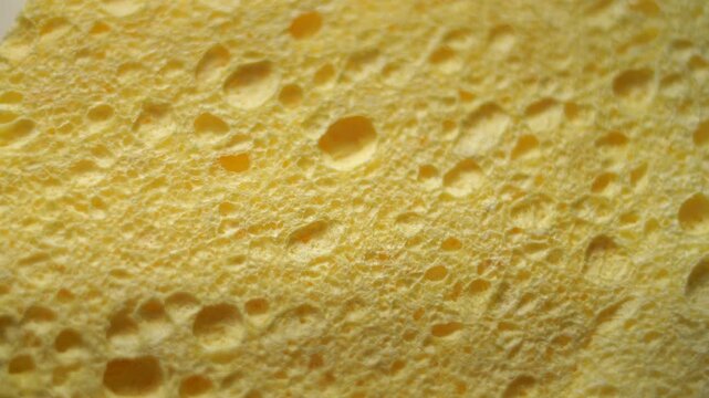 50p extreme close up macro shot of a yellow makeup sponge rotating to reveal texture