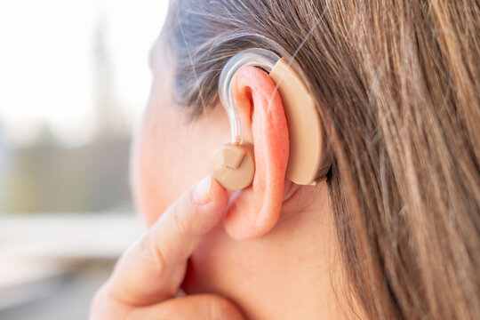 modern behind-the-ear hearing aid on woman's ear improve auditory perception and communication, audiological hearing support, sound device, healthcare assistance, Technological progress ENT medicine