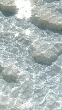 Sunlight sparkling on clear water over white textured salt formations.