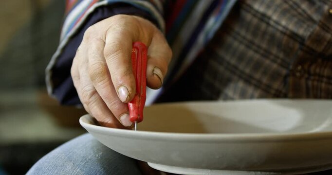 Hand painting traditional ceramic plate with fine brush close-up