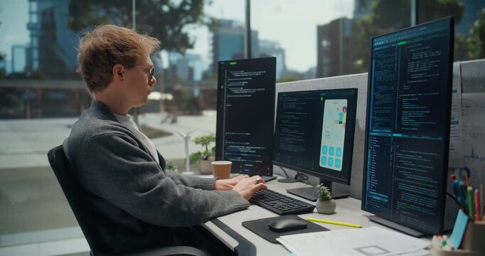 Software Engineer Codes and Tests a Mobile App in a Modern Office, Using Multiple Monitors With Programming Scripts, Interface, Data Charts, Digital Product Development.   Working Using Computer