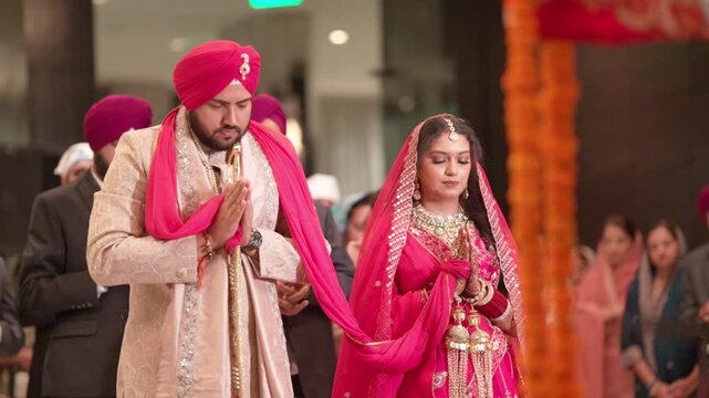 Sikh Bride and Groom with Folded Hands Praying During Traditional Anand Karaj Wedding Ceremony
