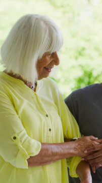Vertical video: Making eye contact at door, nurse in scrubs holding hand, hands joining for comfort