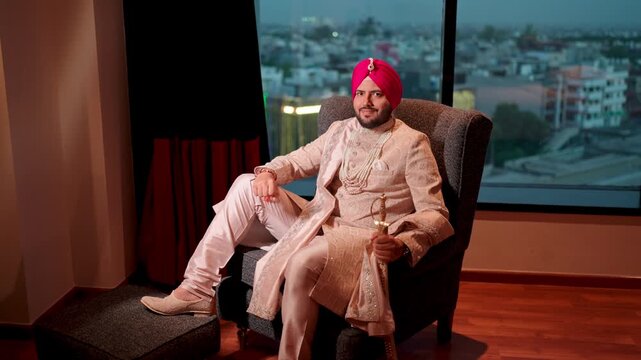 Royal Sikh Groom Sitting on Sofa with Kirpal Smiling in the Camera