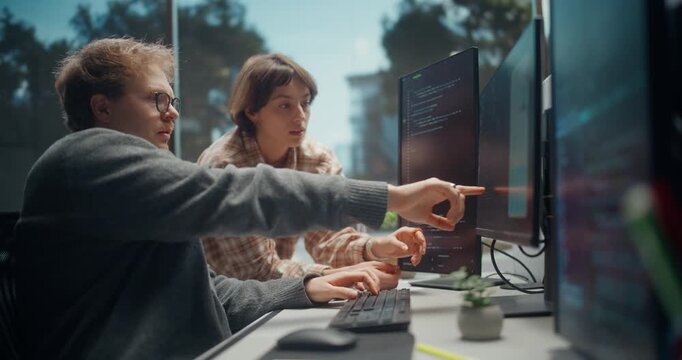 Female Developer and Male UX Partner Work on Mobile Commerce App, Point at Screens, Use AI Coding, Cybersecurity Checks in Video Game Development Studio
