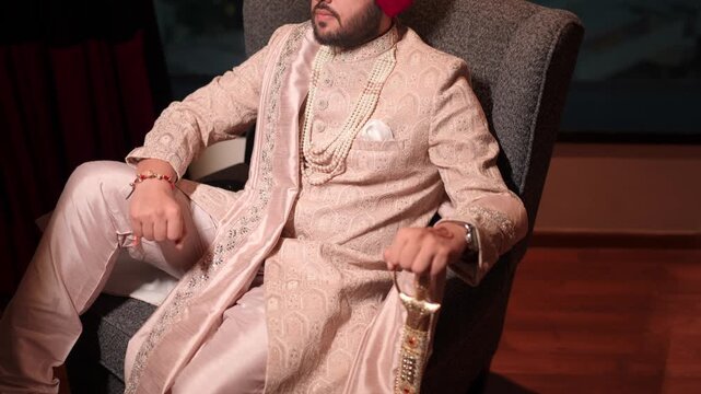 Cinematic Shot of Sikh Groom Sitting on Sofa and Smiling in the Camera