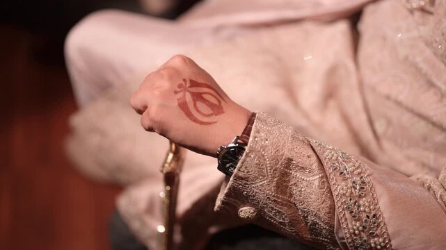 Close Up Of Sikh Groom Hand With Khanda Mehndi Holding Kirpan