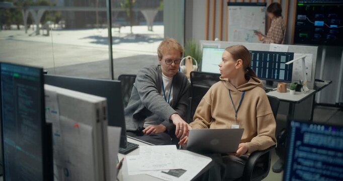 Lead Engineer Talks to Teammate Using Laptop, Dev Team Maps App Architecture, Ai Workflows, Ux Updates and Cybersecurity Tasks, Turning Sprint Feedback Into Ecommerce Product. Using Working Computer