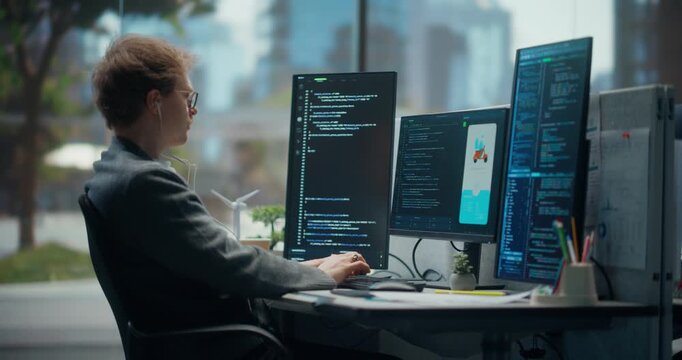 Light-skinned Young Male Programmer Typing and Coding in Bright Office, Using Multiple Displays to Test Mobile App Ui, Debug Backend Automation Flow, With Light-skinned Young Female Designer.