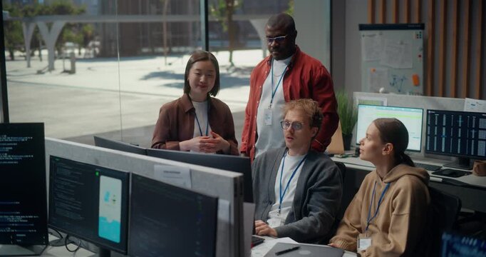 Office meeting, Asian Female and Black Male Engineers Talk With White Male and White Female Teammates, Reviewing App Code on Displays, Pointing, Brainstorming Fixes and Sprint Decisions.