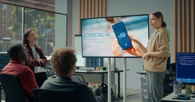Office Meeting Presentation: Young Female Team Lead Presents Ethical AI on a Big Screen to Diverse Software Developers in Office, Sparking Discussion on Mobile App Design, Coding and Cybersecurity.