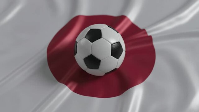A soccer ball rests on a waving Japanese flag, symbolizing the nation's passion for football. The fabric ripples gently in a continuous loop.