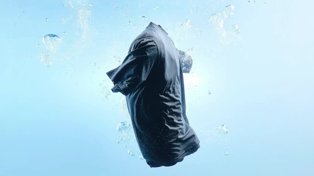 Black T-shirt floating in water, T-shirt in clear blue water with bubbles. Oxygen bleach, washing, stain remover, and cleanliness of linen