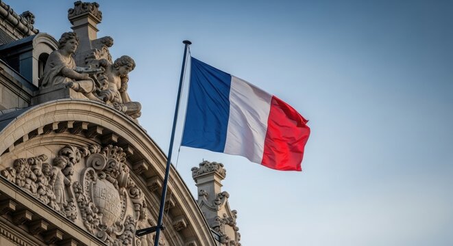 French flag waving in the wind against a historic building facade