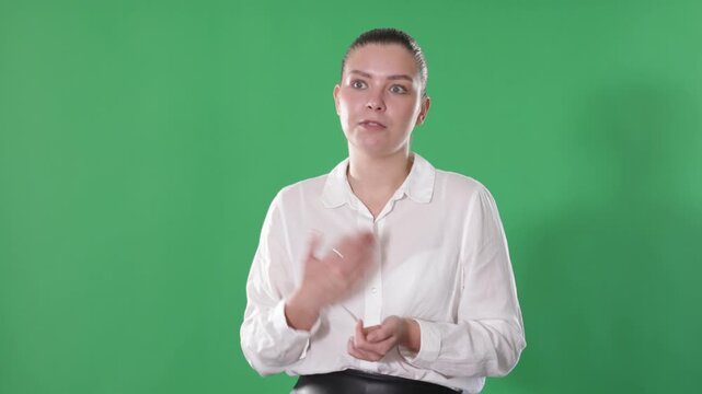 European woman in office clothes standing on the background of chrome key, gesturing and talking. High quality 4k footage