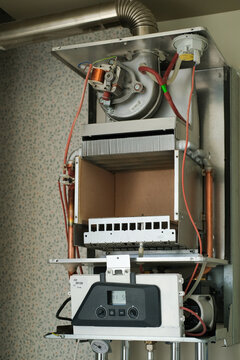Open gas boiler during maintenance and cleaning in residential apartment heating system.