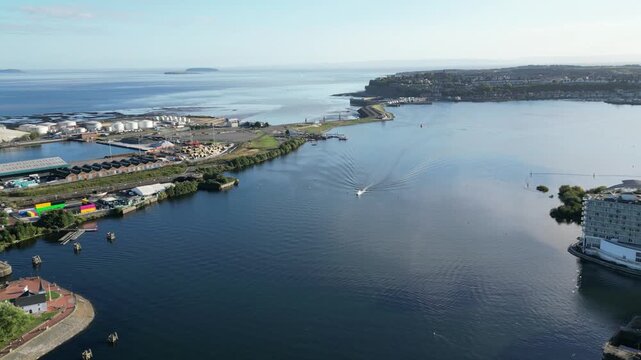4K Aerial Drone Fly‑Over of Cardiff Bay and Penarth Coastline Featuring Boat Movement Across Tranquil Water Under Blue Sky, Wales, United Kingdom