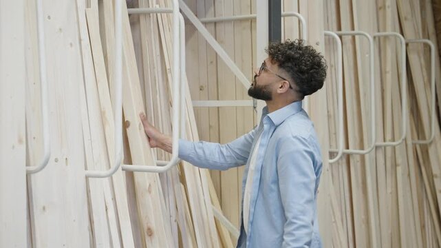 Carpenter choosing wooden planks in hardware store