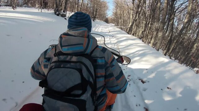 Snowmobile adventure through a snowy forest trail during winter